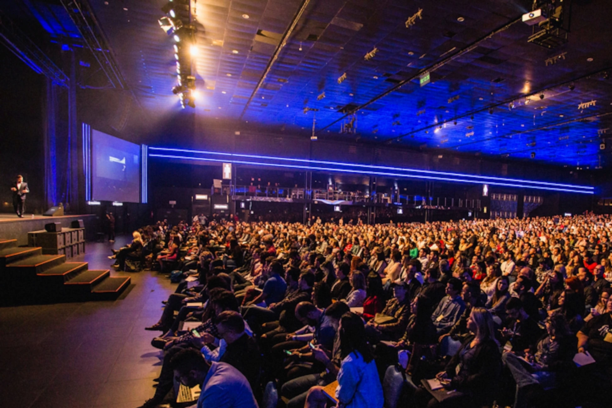 man talking in a big room with crowd